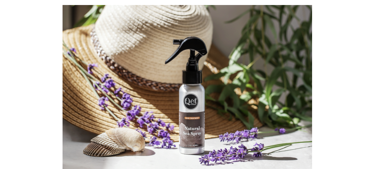 Natural Sea Spray with seashells, lavender flowers, and a straw sun hat.